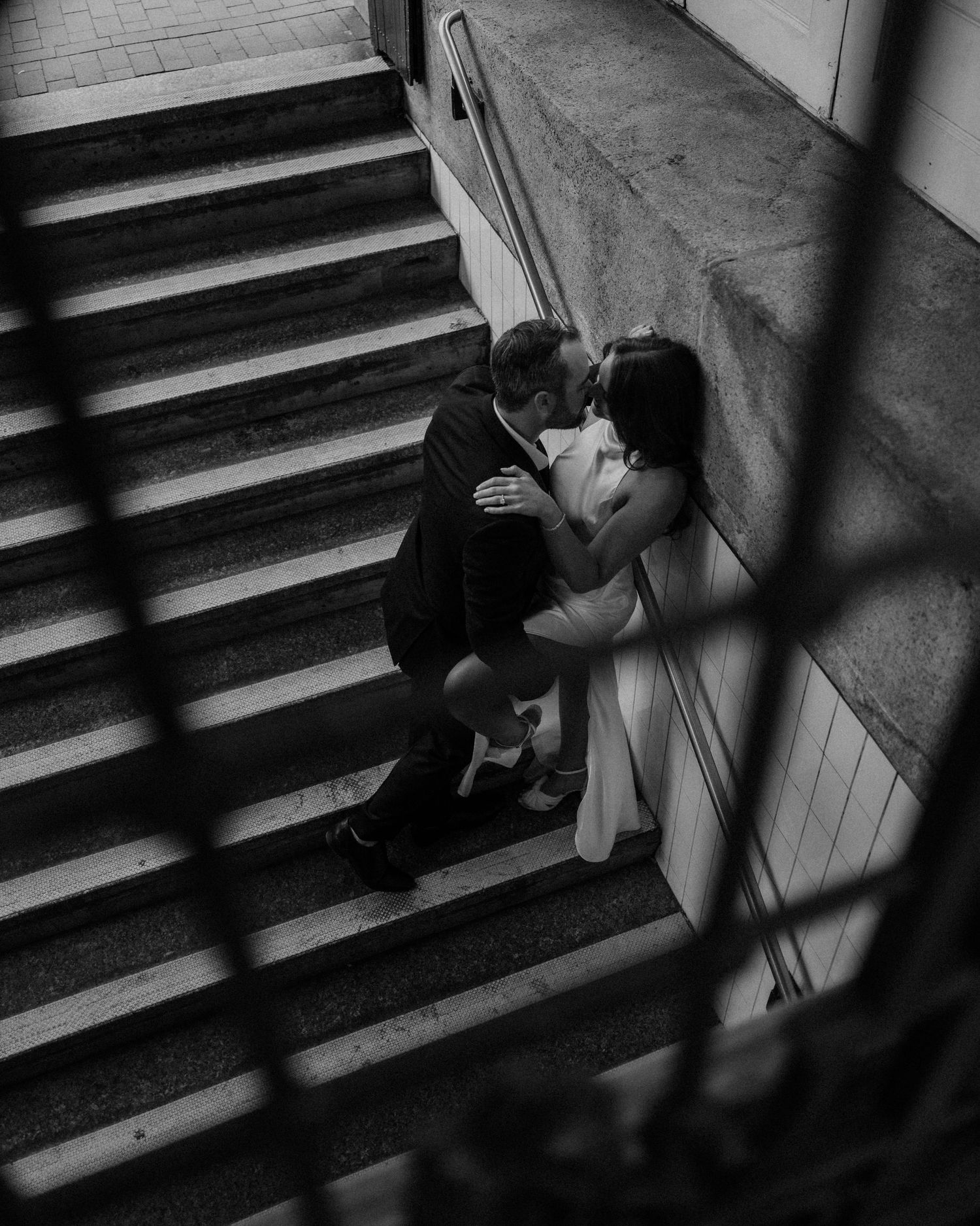 A sequence of dramatic black and white photos shows someone sitting alone on concrete stairs in shadows.