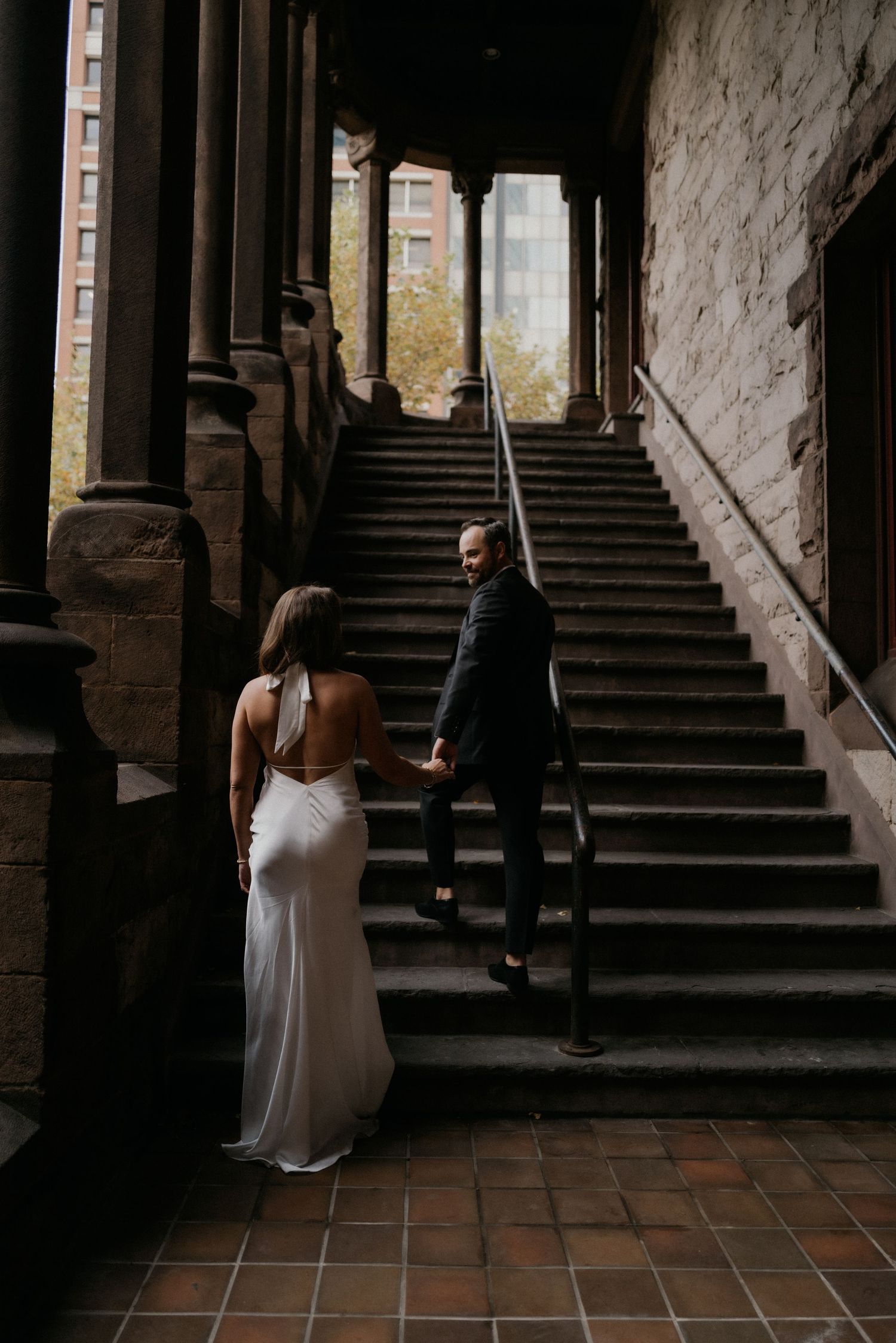 A sequence of intimate wedding moments captured in a dark stone archway with stairs.