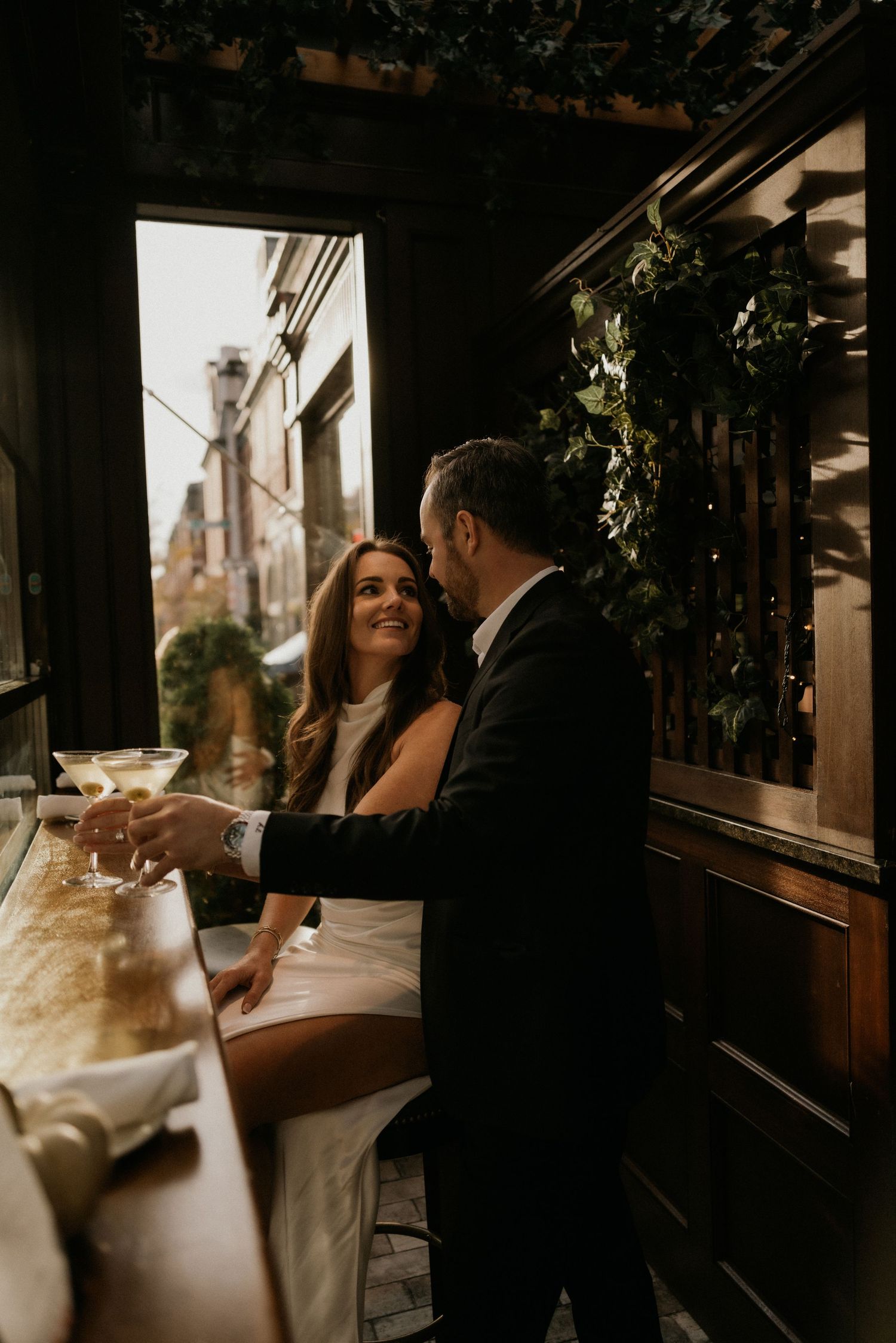 A romantic moment captured between a couple at an intimate restaurant setting featuring warm lighting and vintage decor.