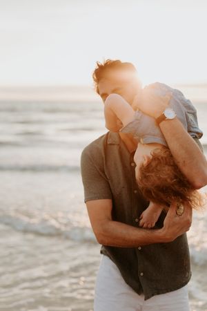 A Dad and his daughter play at the beach during a golden hour photography session with a professional Adelaide photographer Lauren Lunn.