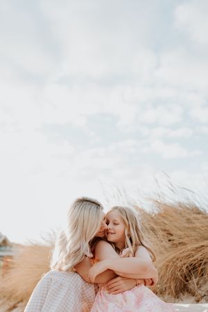 A golden sunrise lights up an Adelaide beach as mother and daughter enjoy a playful moment together during a photography session.