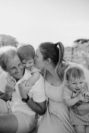 A pro Adelaide photographer captures a family laughing and playing together on the beach at sunset for their family photography session.