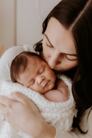 Lauren Lunn Photography captures mum sharing a loving moment with her newborn in gorgeous neutral blankets in Adelaide baby studio.