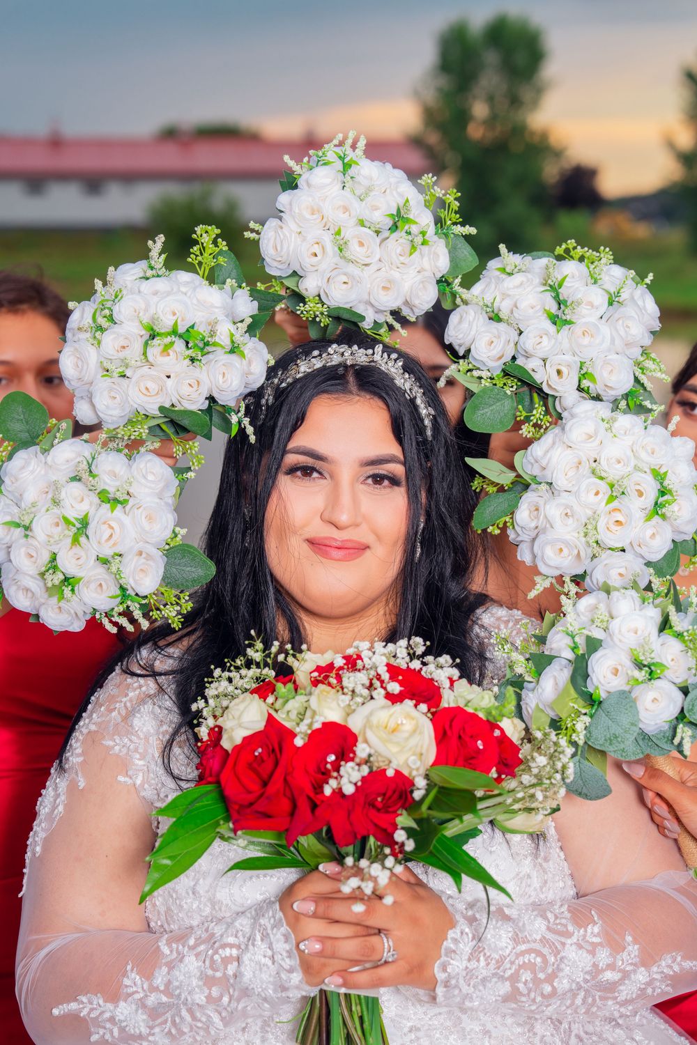 Bridal portrait with white floral crown and red rose bouquet against evening sky. Appleton Photographer.
