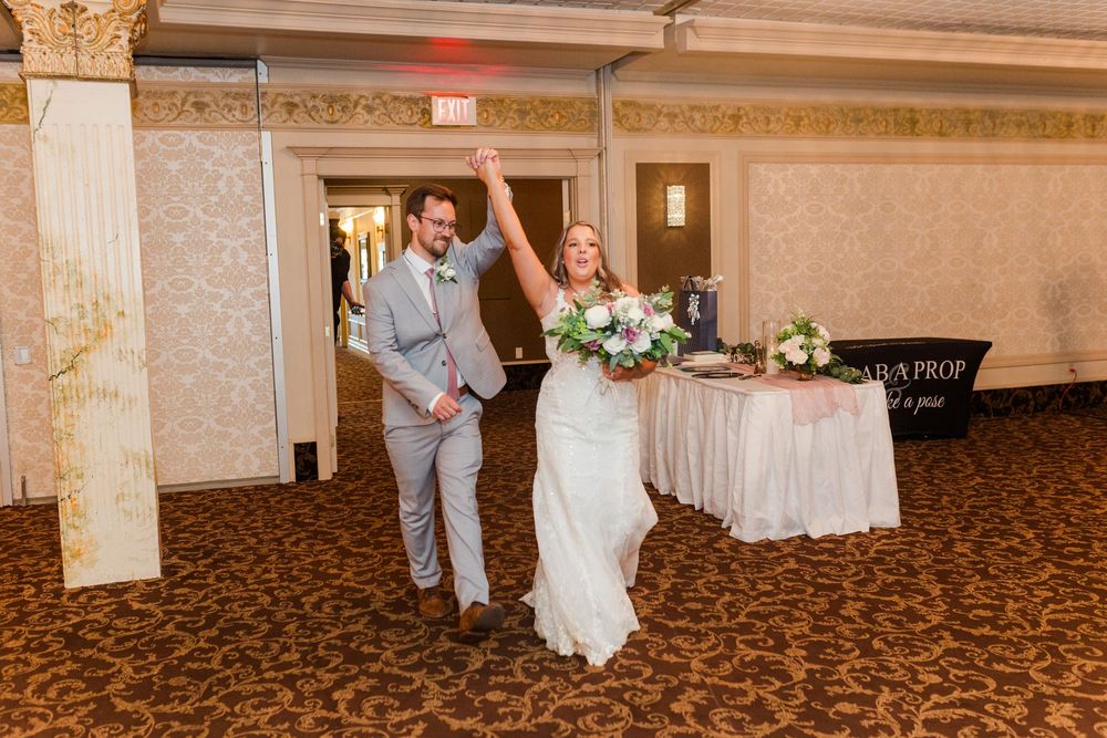 Wedding reception celebration at an elegant venue with decorative white floral arrangements.