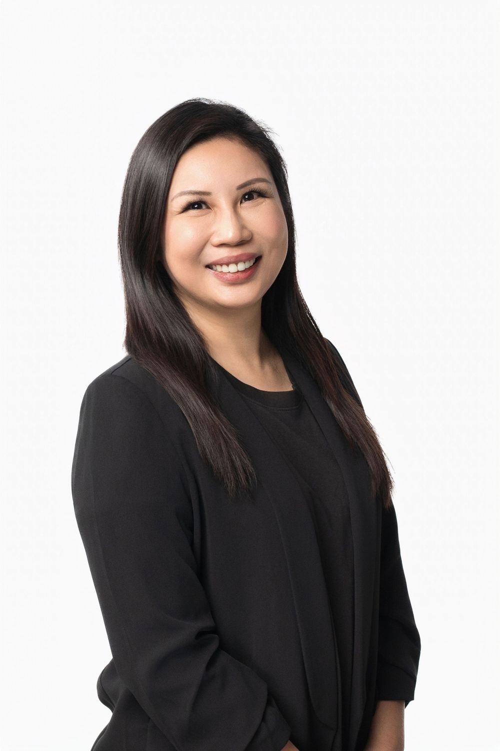 Professional headshots showing woman in black top against white background smiling warmly at camera.
