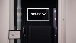 Black door with illuminated SPARK signage in white lettering.