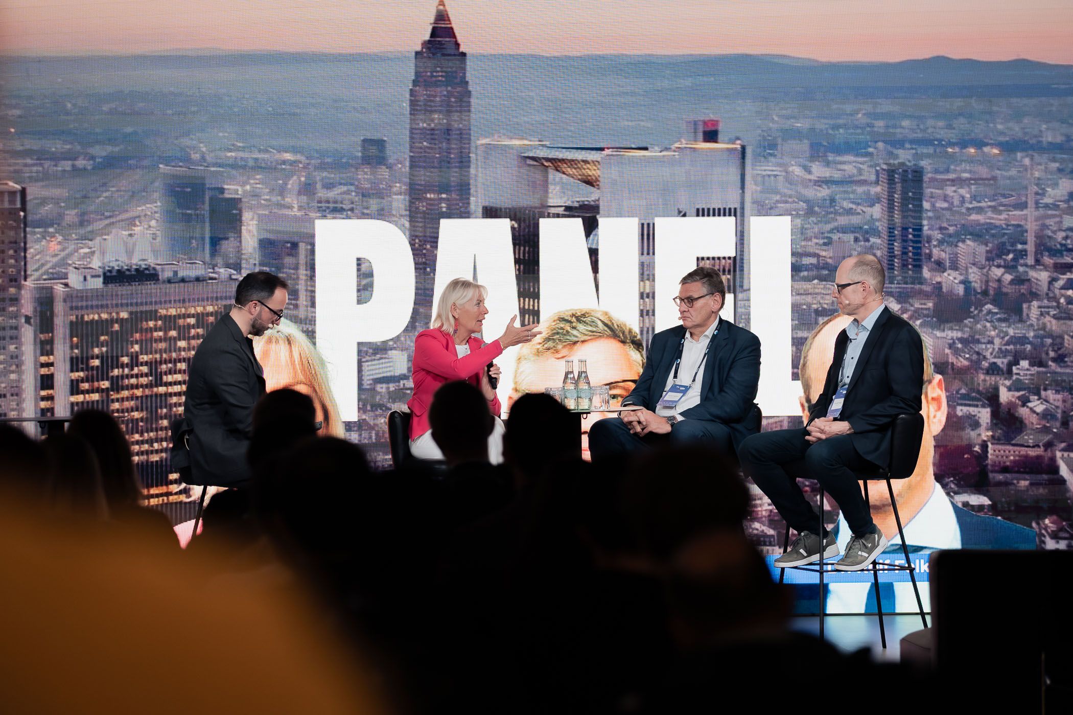Panel discussion setup with cityscape backdrop at professional conference.