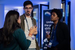 Three professionals having an animated conversation during a business networking event.