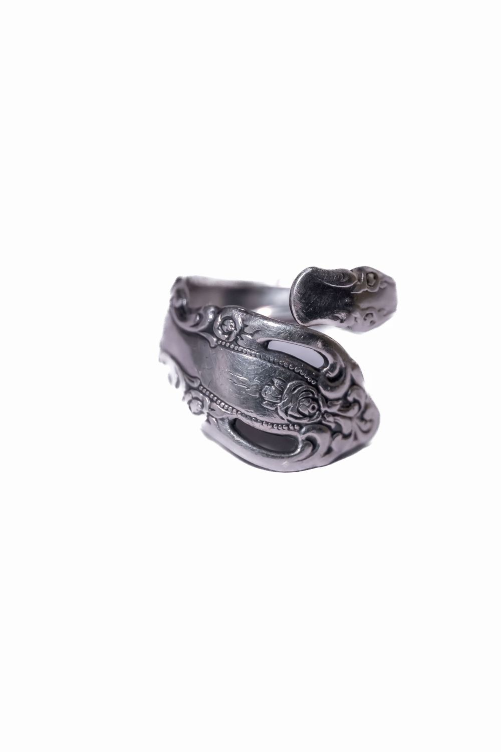 Upcycled silverware ring featuring detailed floral and scroll patterns.
