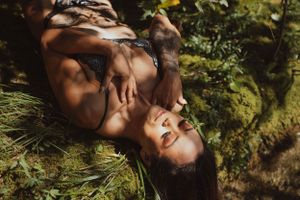 Artistic outdoor portrait with dramatic shadows and natural greenery.