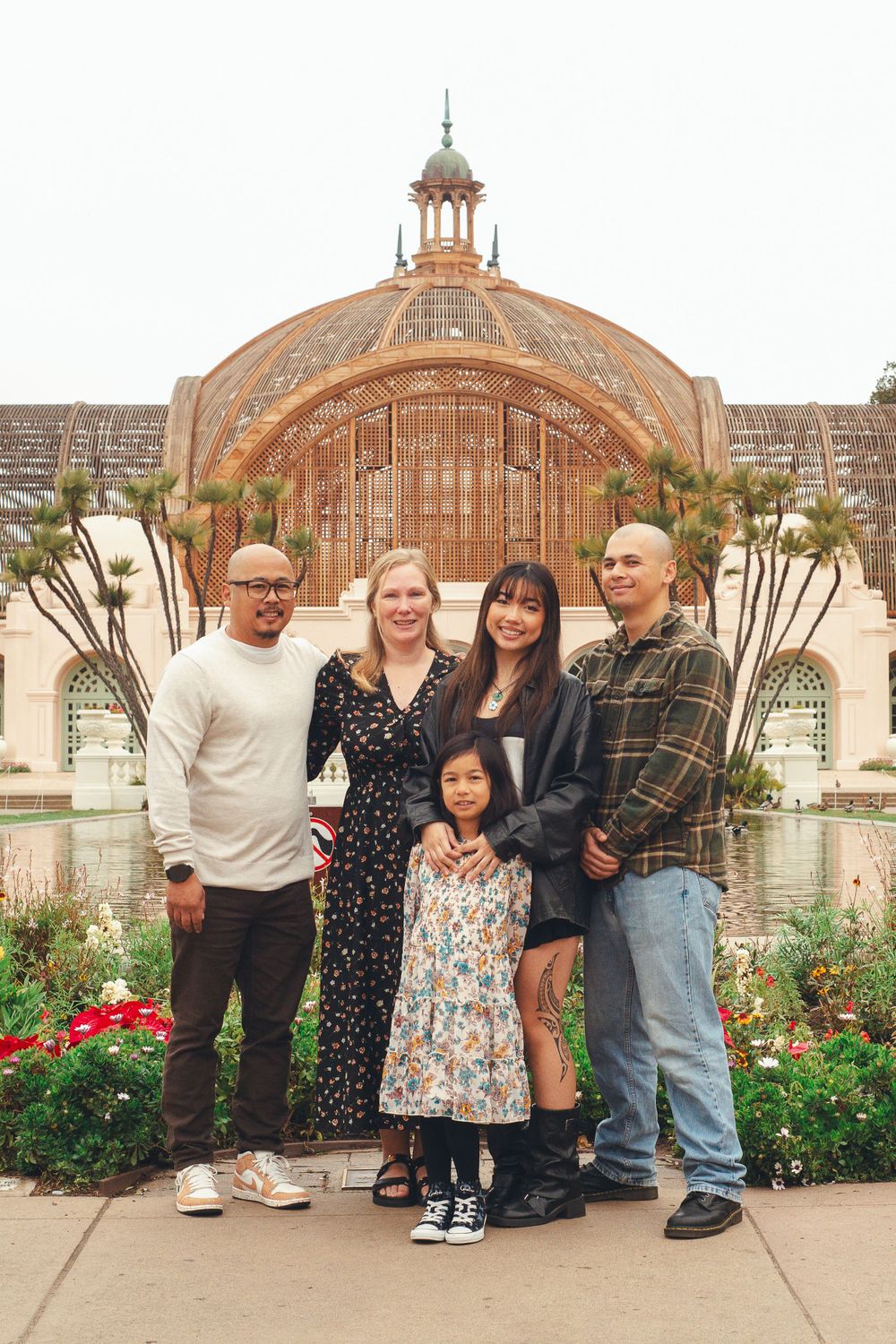 Family of five smiling in front of Balboa Park Botanic Gardens in san diego ca