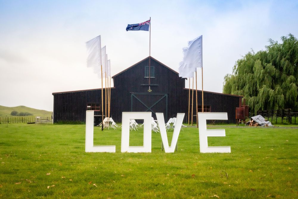 Wedding venue with oversized letters spelling out the word love with flags on each side.