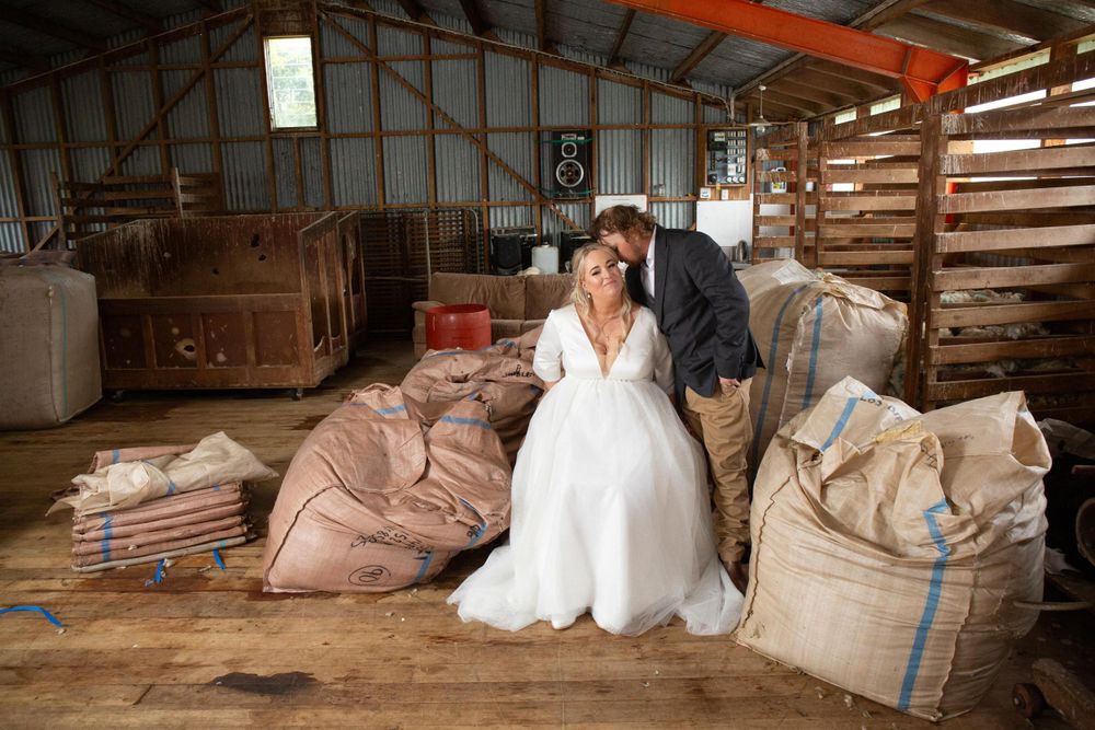 Wedding photo of a bride and groom inside of a wool shed. Hawkes Bay, New Zealand.