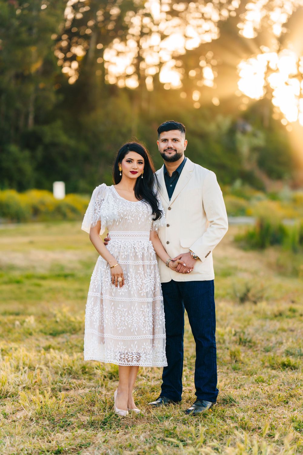 Formal couple portrait in white and navy outfits during sunset photoshoot.