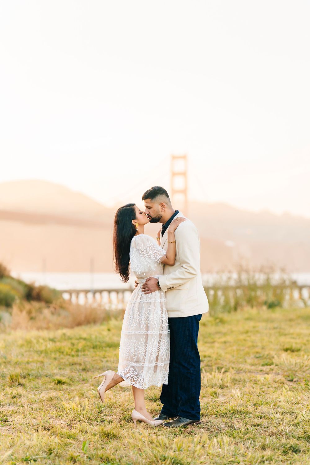 A romantic moment captured near the Golden Gate Bridge at sunset.
