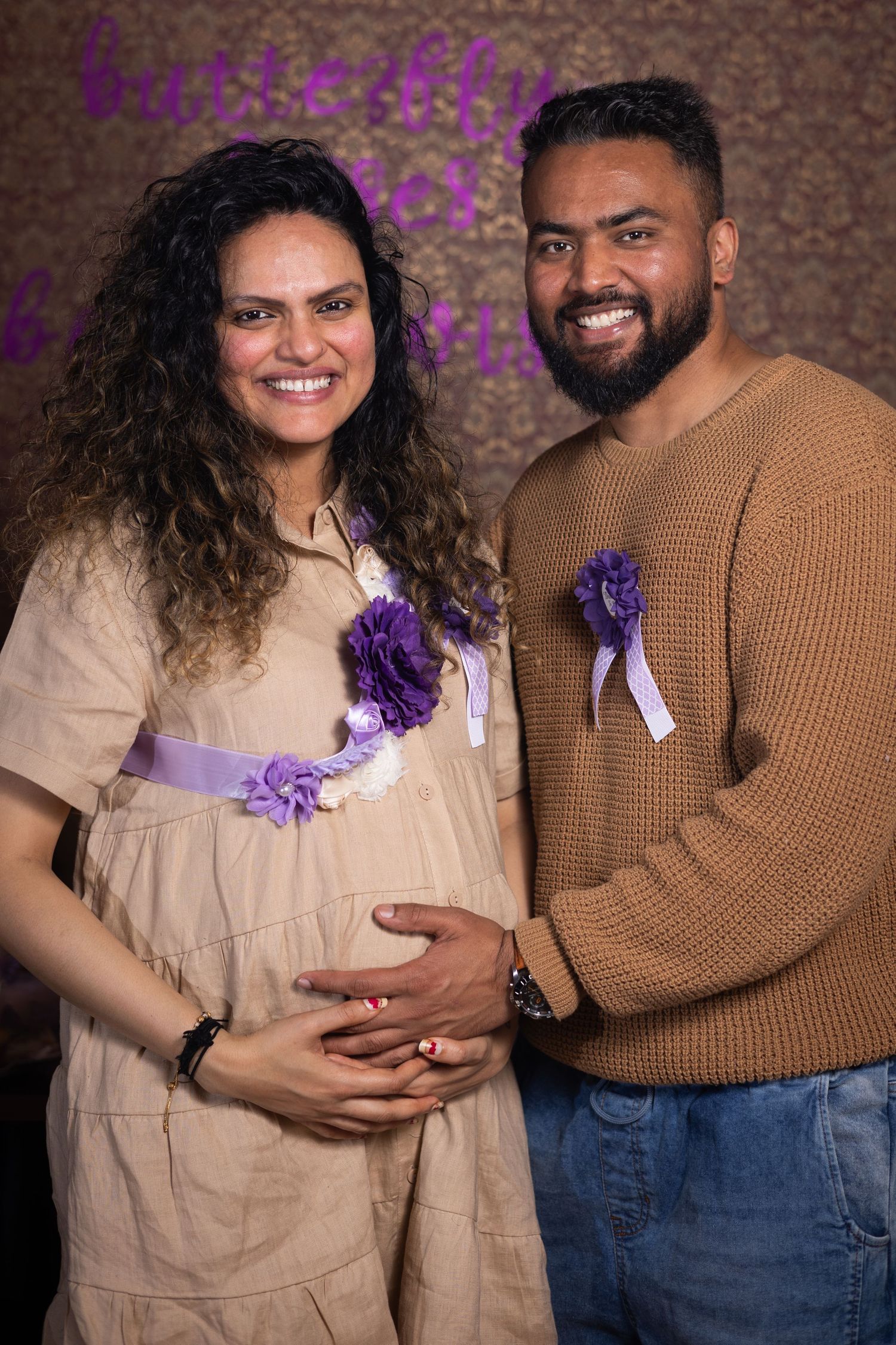 A young Indian couple smiling during a baby shower
