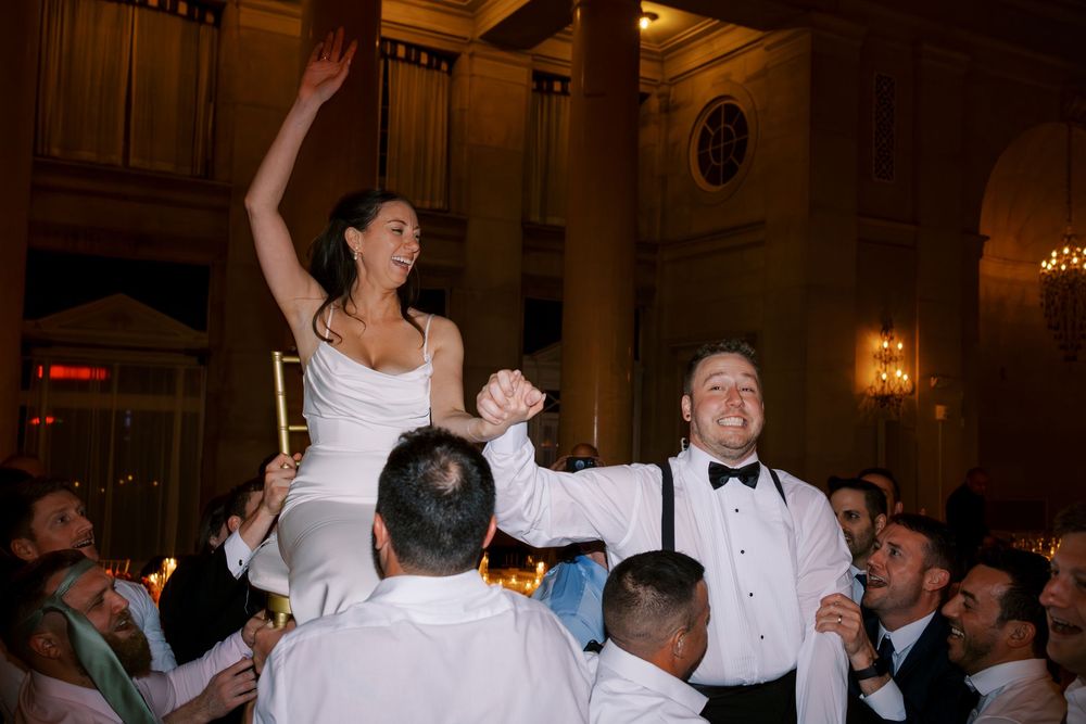 Bride and groom being lifted on chairs during a hora dance celebration at an elegant wedding reception at Hall of Springs.