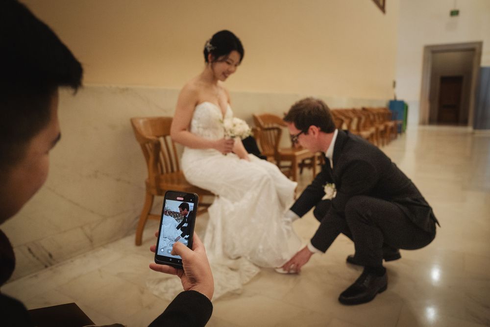 Wedding photoshoot shows couple posing on marble floor of elegant venue.