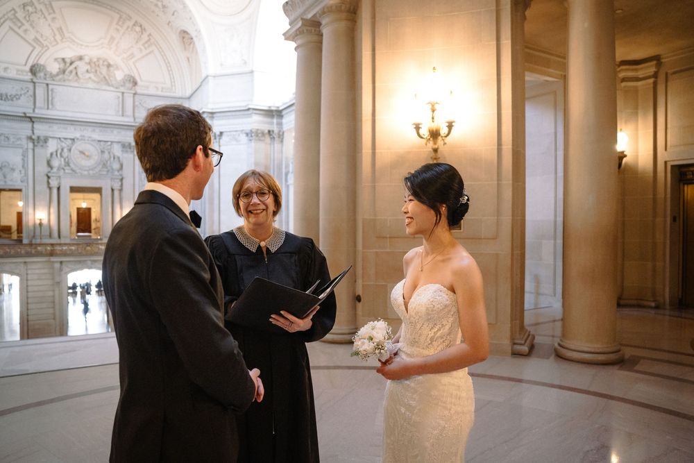 Wedding photography session in ornate classical building with columns and grand architecture.