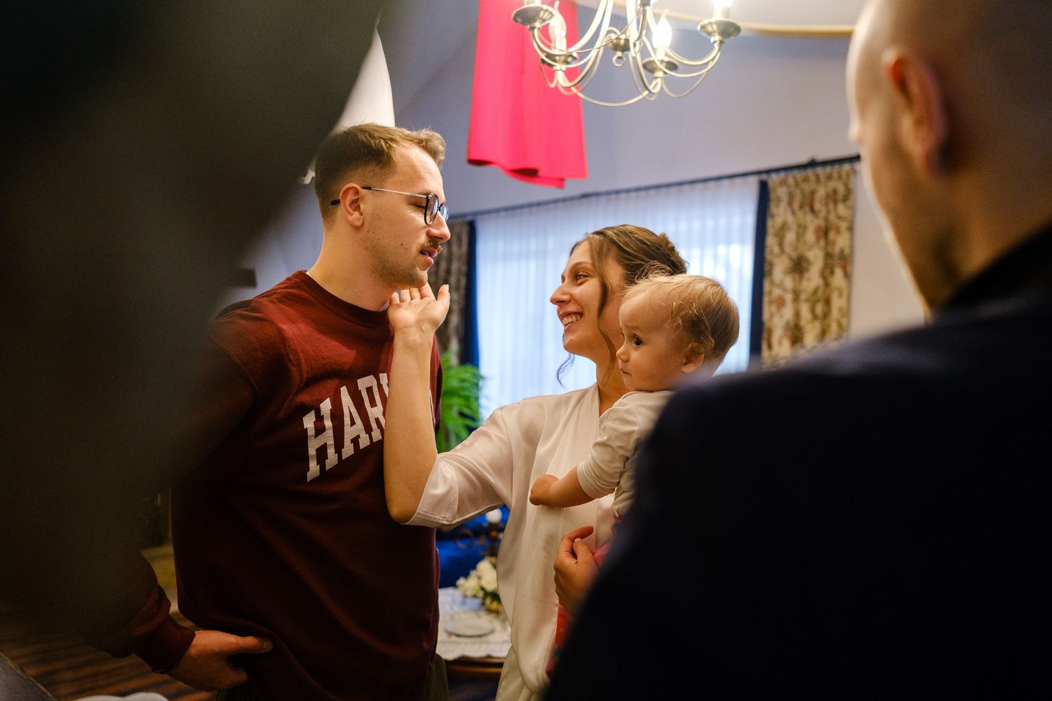 Panna młoda wita się z panem młodym, podczas przygotowań przed ślubem w domu.