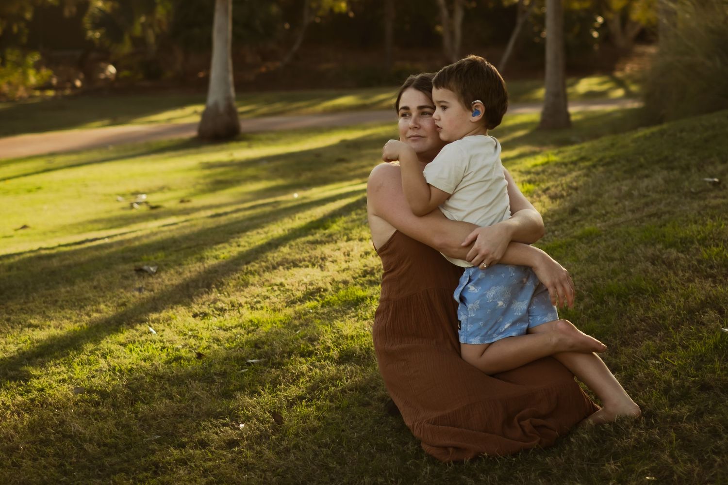 Candid family moments captured in warm sunlight at a park during golden hour.