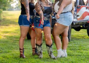 Group wearing matching denim shorts and boots standing together outdoors.