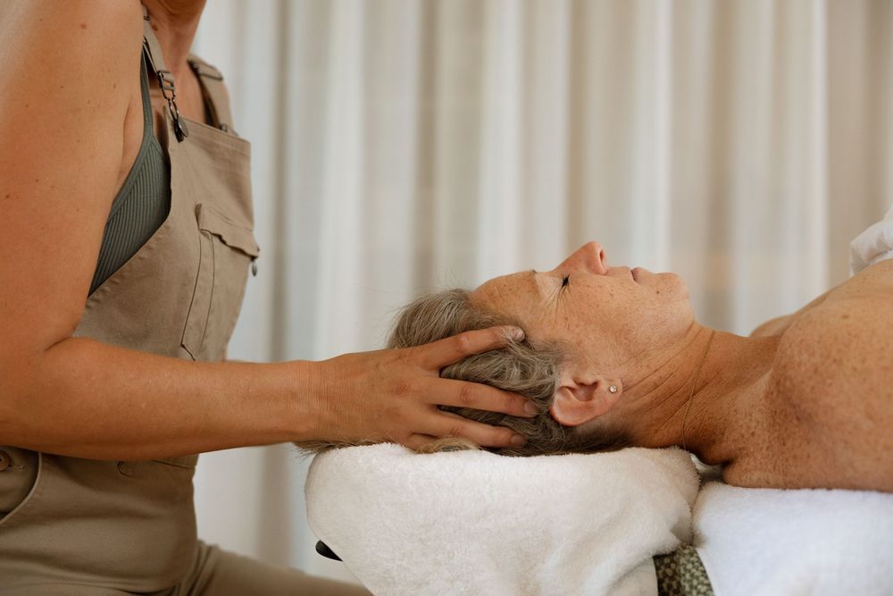 Professional spa therapist performing relaxing facial massage treatment on client.