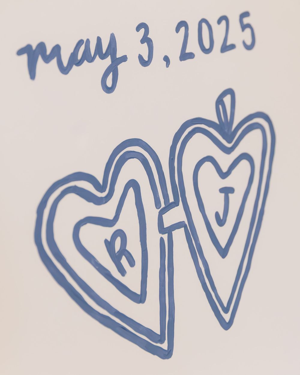 Two hand-drawn blue hearts with letters R and J inside, dated May 3, 2025.