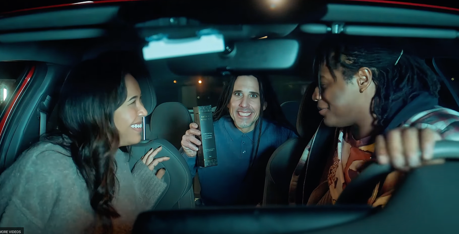 Interior view of car passengers at night with blue lighting.