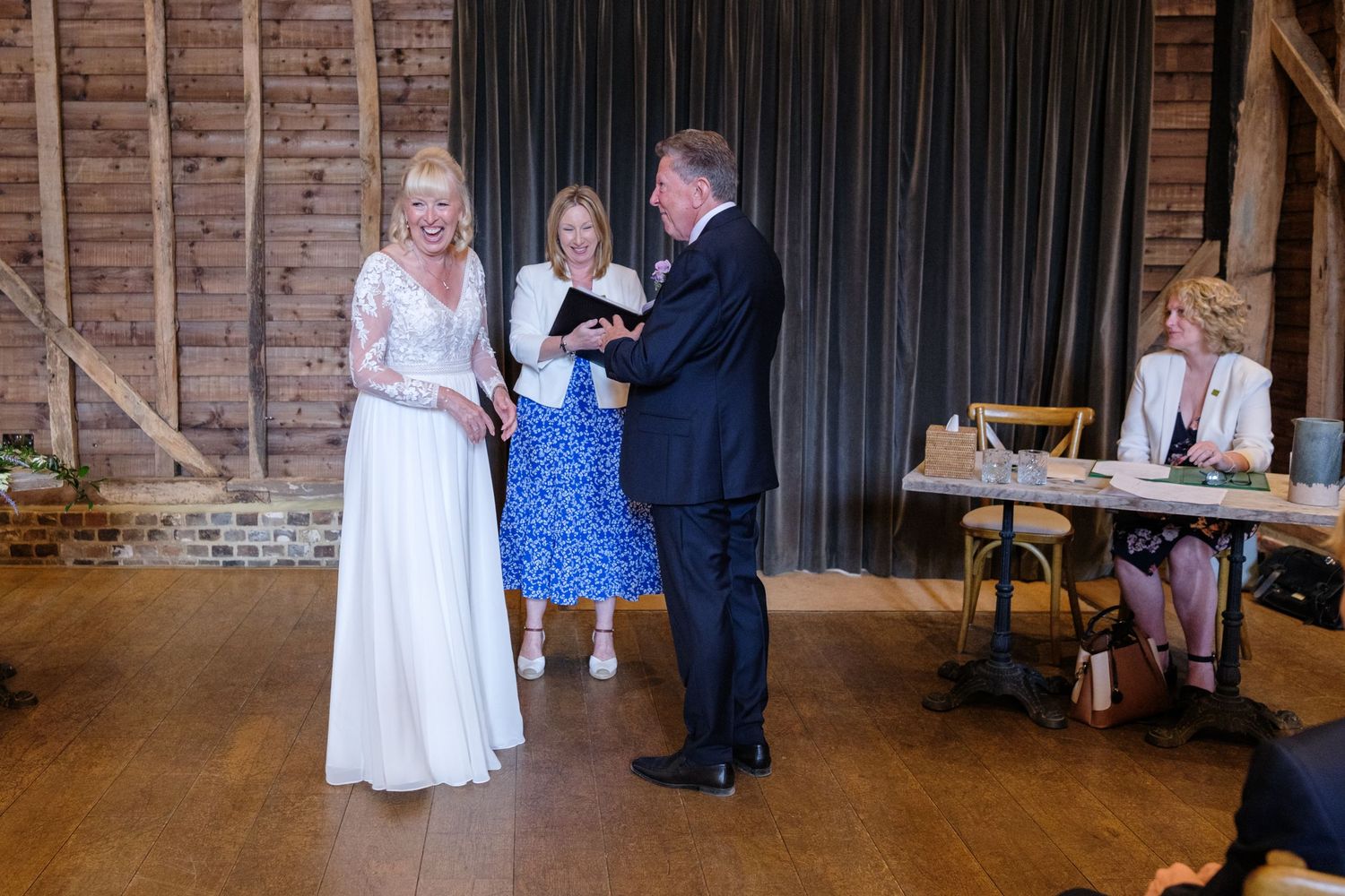 Wedding celebration in a rustic barn venue with guests gathered for a ceremony.