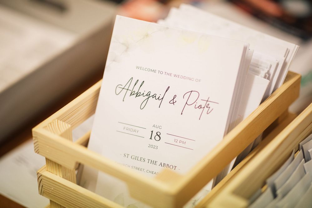 Wedding invitation for Abigail and Pete displayed in a wooden box with elegant calligraphy script.