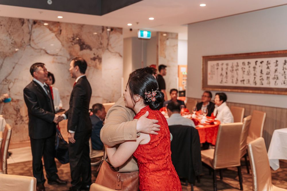 Restaurant dining room decorated with traditional Chinese artwork featuring servers and guests during a special event.