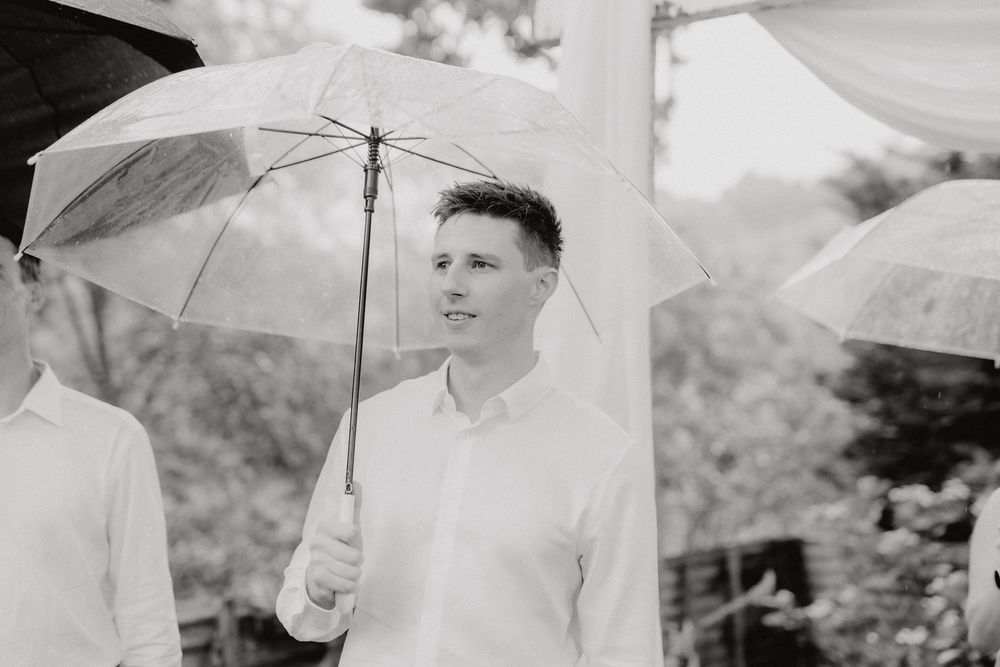 Black and white photo showing umbrellas being held in an outdoor setting on an overcast day.