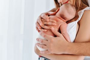 Loving embrace shown with hands against white background.