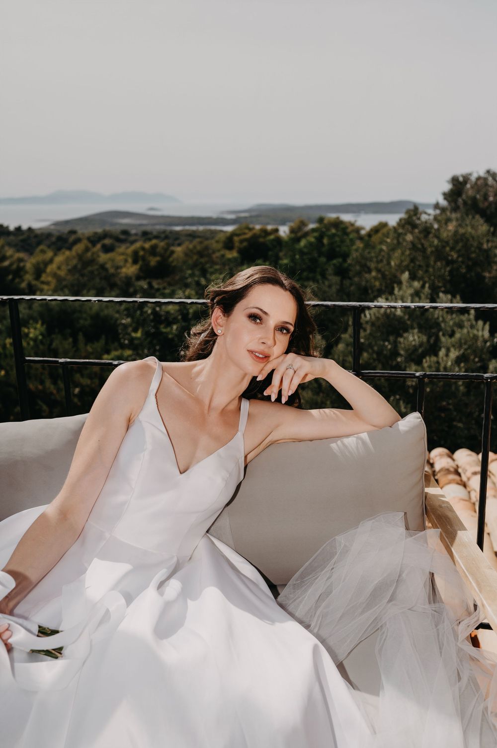 Mladenka sjedi na vanjskoj garnituri okrenuta prema suncu – bezvremenski bridal mir.