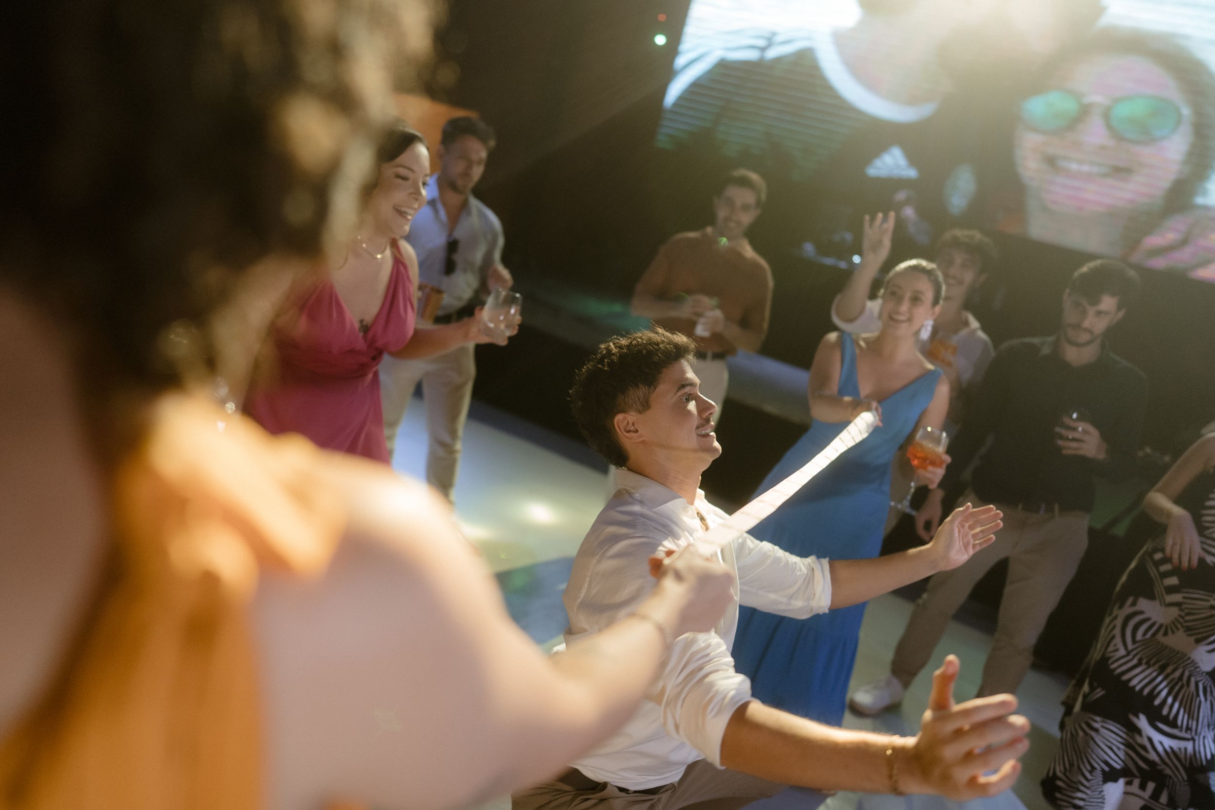Energetic dance party scene with guests celebrating under blue lighting.