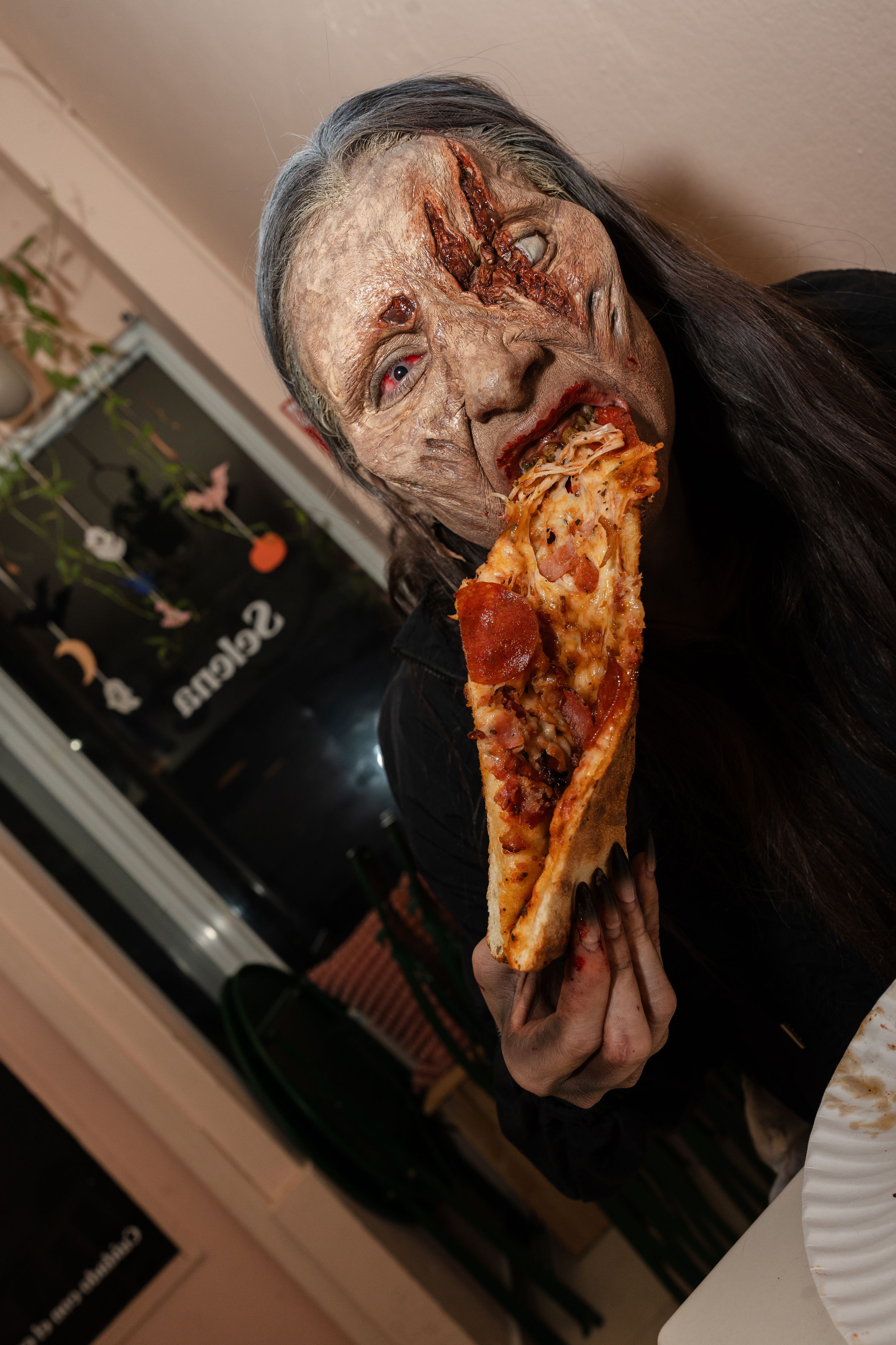 Zombie eating a pizza.