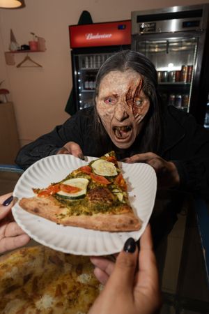 Zombie eating a pizza.
