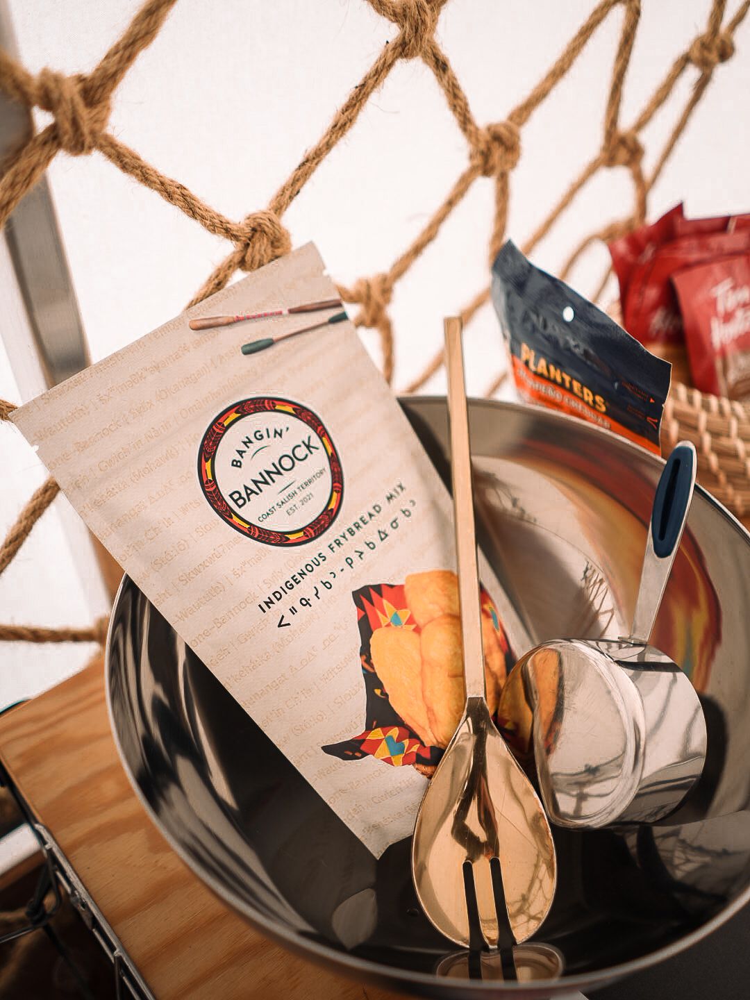Paper bags with branded labels sit on a wooden surface.