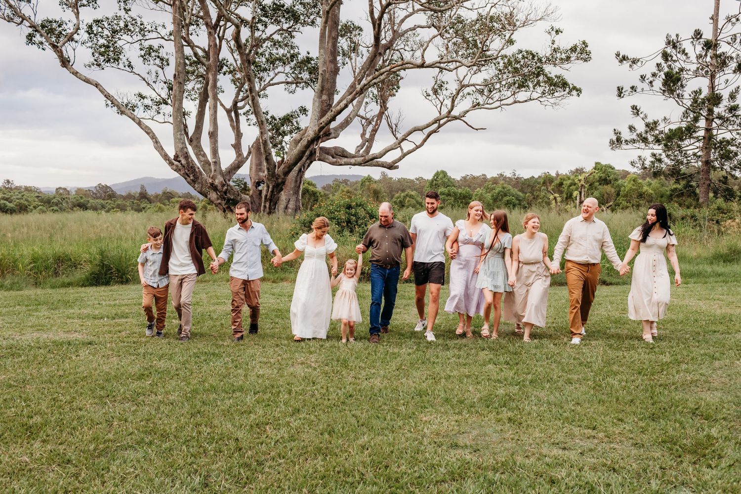 Large group in coordinated outfits walking together across a grassy field.