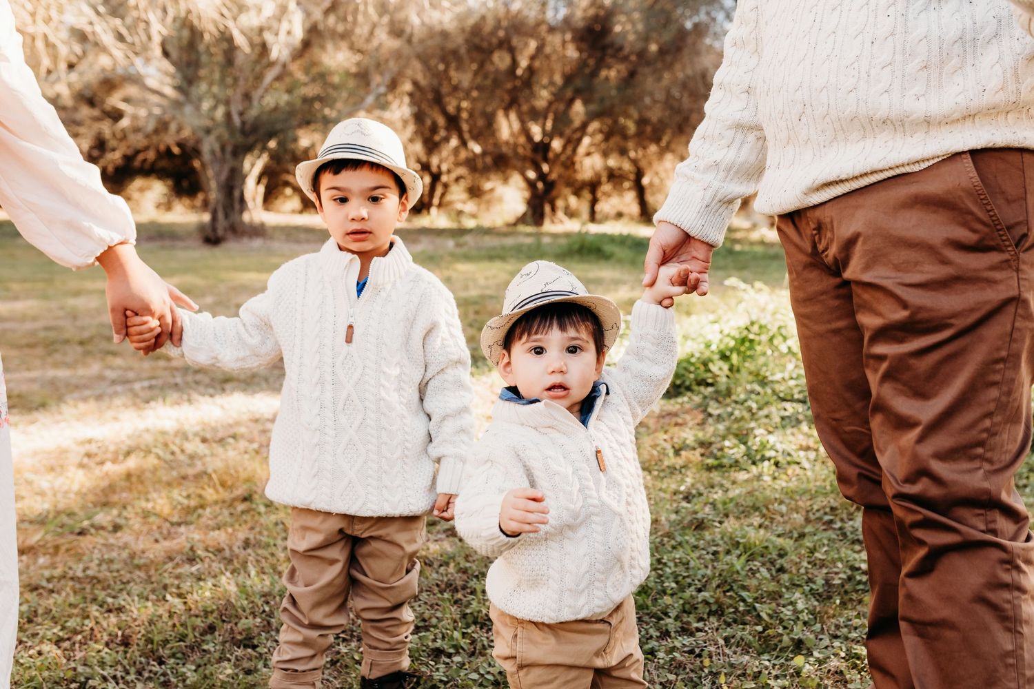Children playing together outdoors in coordinated brown and white outfits.
