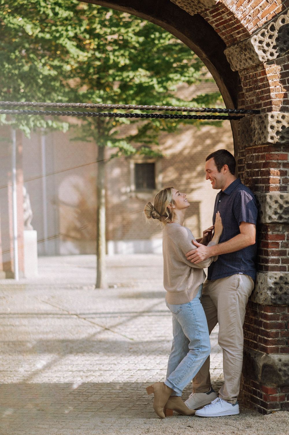 Romantic scene under a brick archway beside a canal in Amsterdam.