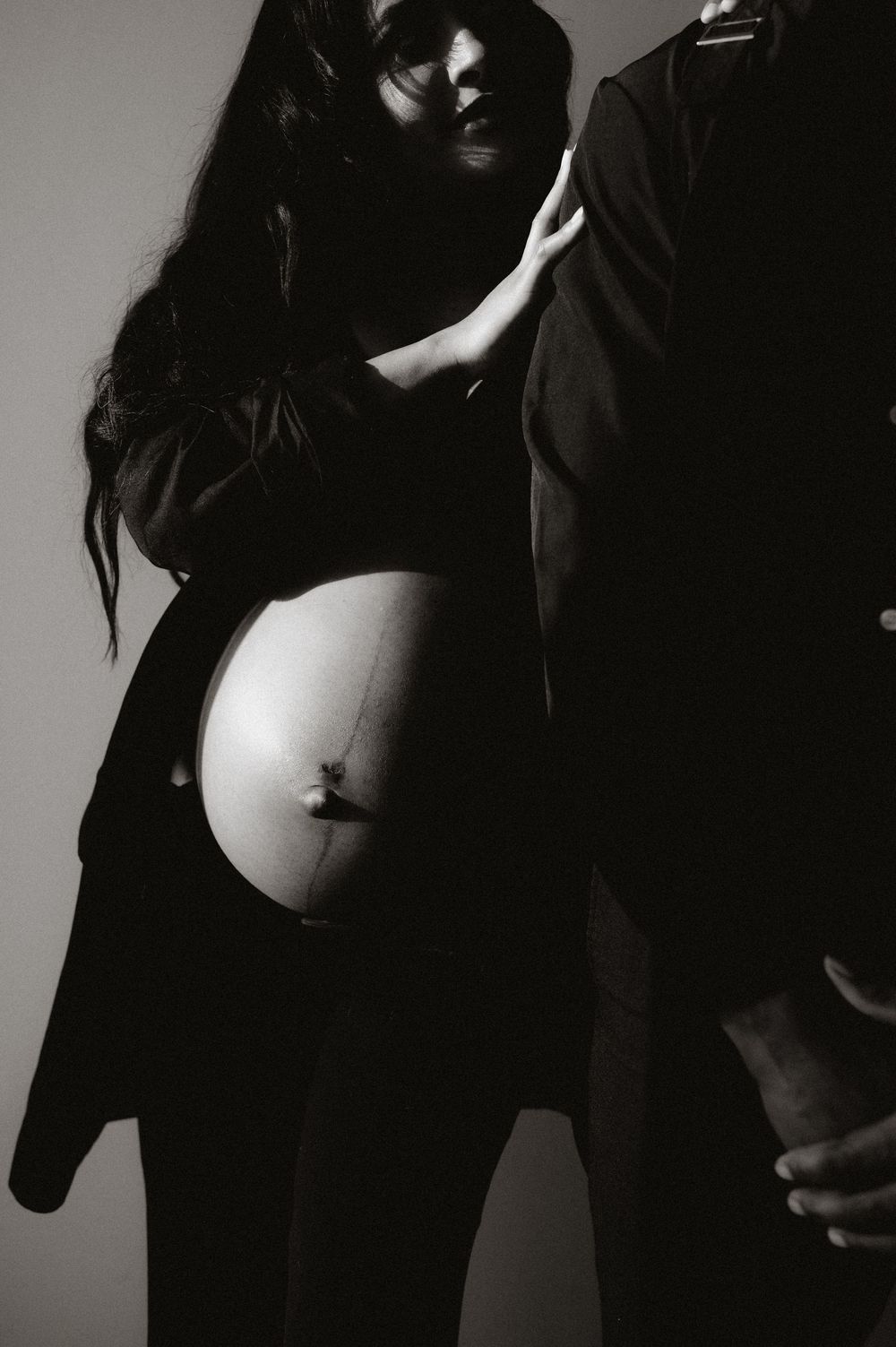 Dramatic black and white maternity photoshoot sequence showing silhouette and curves.
