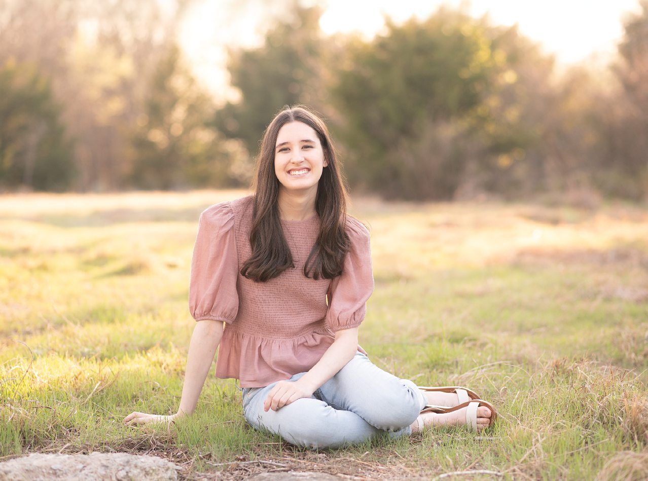 Senior Girl portraits for in Light Grassy Field with Spring Blossoms by Bartlesville Photographer Kristi Bray