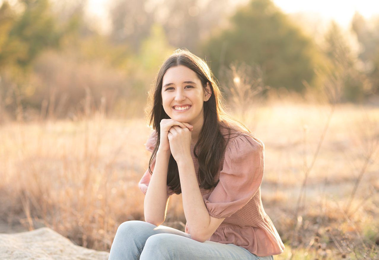 Senior Girl portraits for in Light Grassy Field with Spring Blossoms by Bartlesville Photographer Kristi Bray