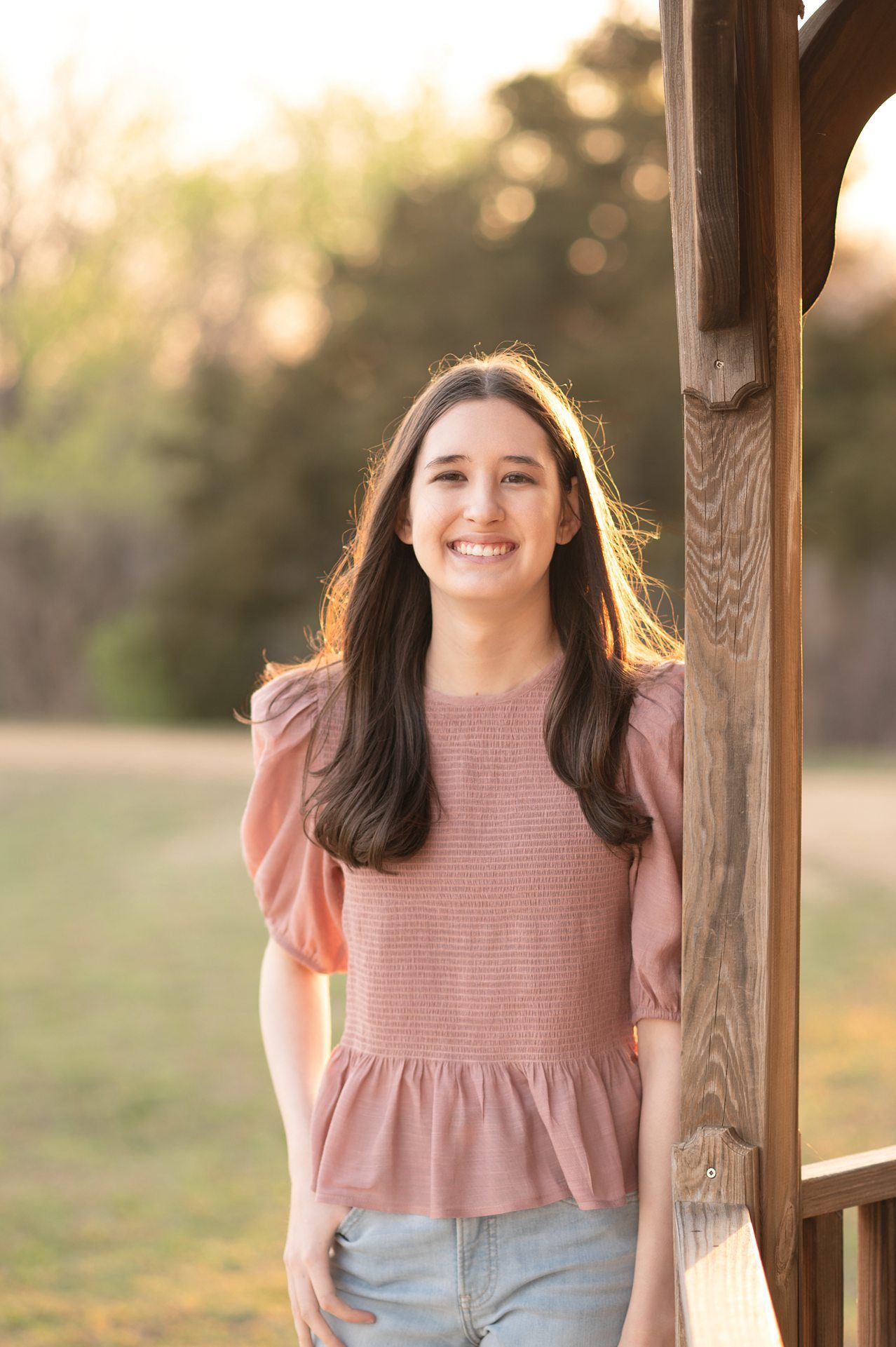 Senior Girl portraits for in Light Grassy Field with Spring Blossoms by Bartlesville Photographer Kristi Bray
