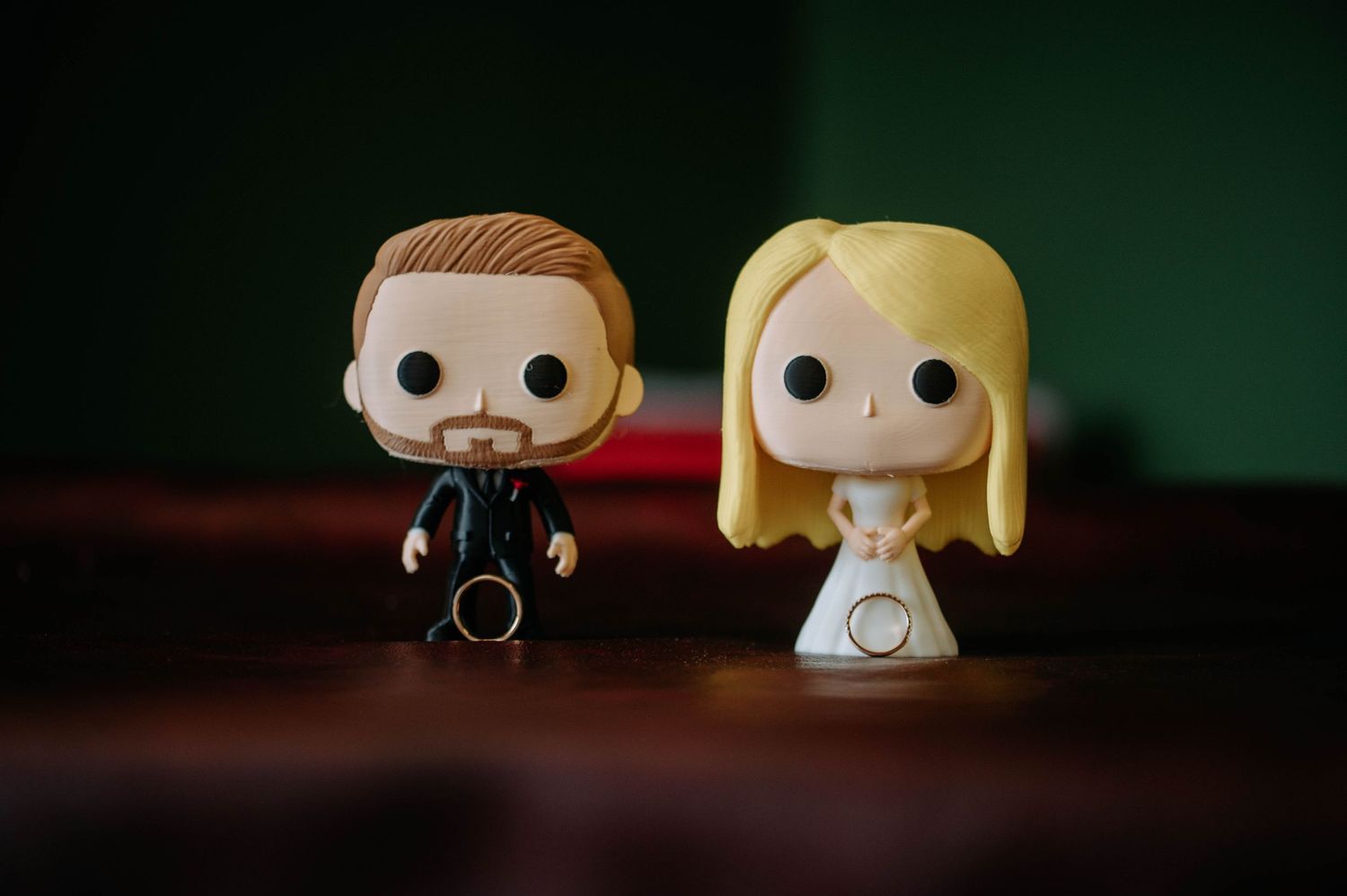 Two Funko Pop figurines, one in a black suit and one in white, displayed against a dark background.