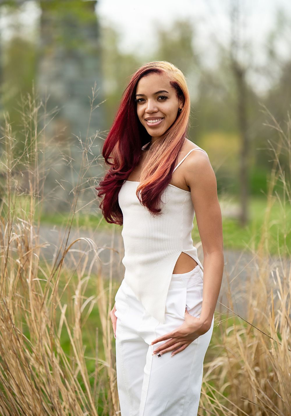 Outdoor fashion portraits in white dress with rustic field backdrop.