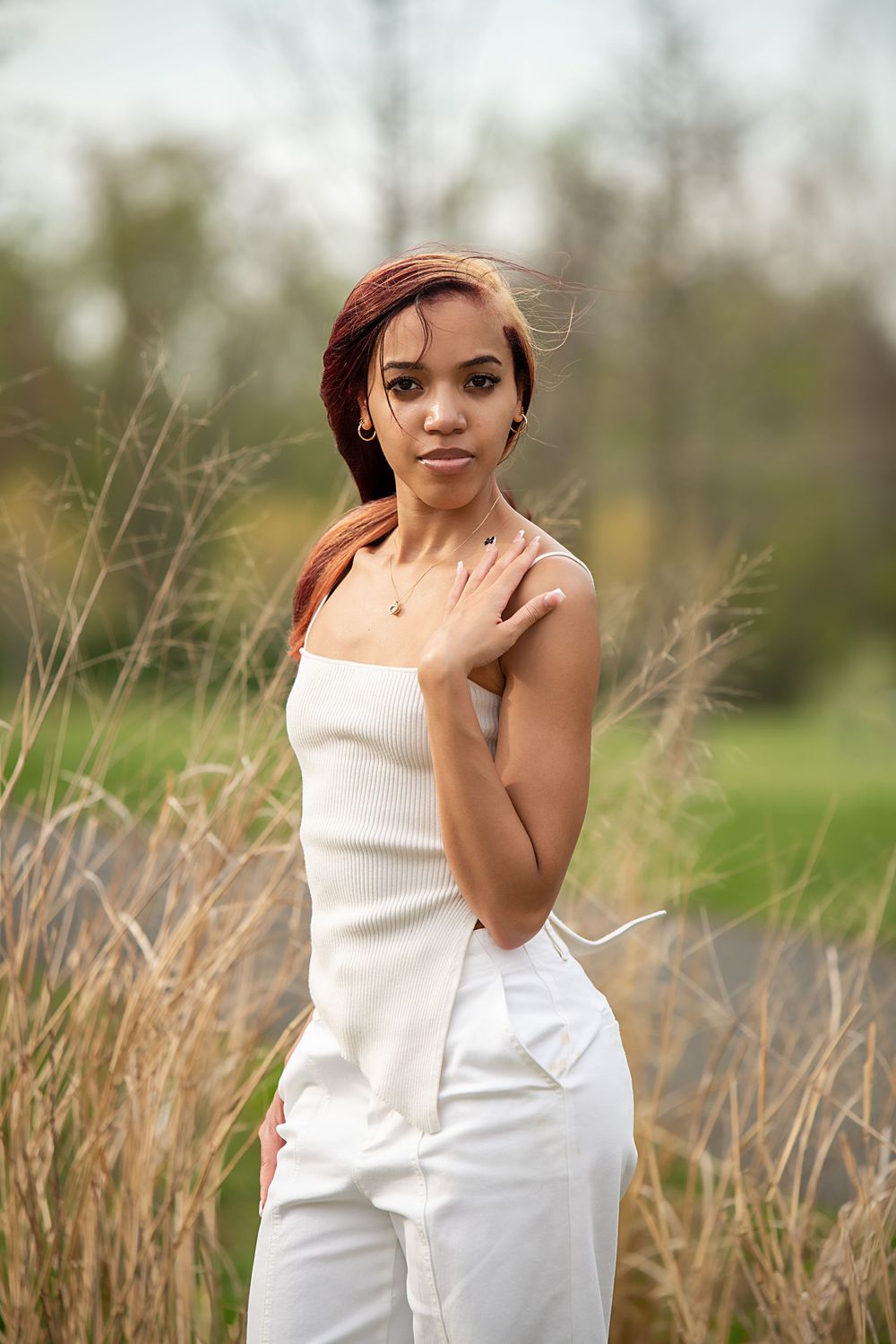 Portrait series in white dress against natural field setting with dried grasses.
